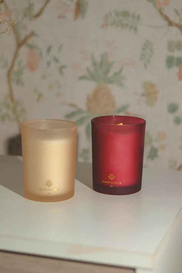 Phone photo: two candles on a dresser by wallpaper